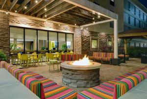 eine Terrasse mit einer Feuerstelle sowie Tischen und Stühlen in der Unterkunft Home2 Suites By Hilton Bordentown in Bordentown