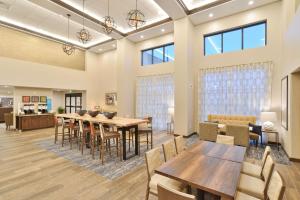 un comedor con mesas, sillas y ventanas en Hampton Inn & Suites Menomonie-UW Stout en Menomonie