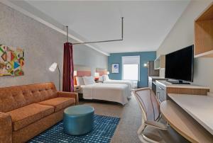 ボーデンタウンにあるHome2 Suites By Hilton Bordentownのベッドとソファ付きのホテルルーム