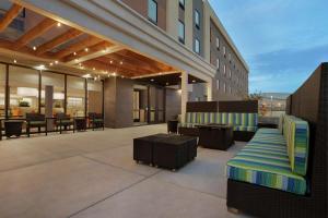 a building with a patio with a bench and tables at Home2 Suites By Hilton Elko in Elko