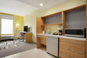 een kamer met een keuken met een magnetron en een bureau bij Home2 Suites By Hilton Elko in Elko
