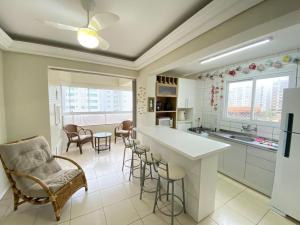 eine Küche mit einer Theke und Stühlen in einem Zimmer in der Unterkunft Apartamento capão da canoa in Capão da Canoa