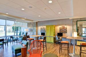 un restaurante con sillas coloridas, mesas y ventanas en Home2 Suites By Hilton Winston-Salem Hanes Mall, en Winston-Salem