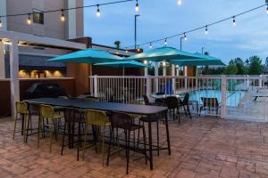 a patio with tables and chairs and blue umbrellas at Home2 Suites By Hilton Jackson Flowood Airport Area in Flowood