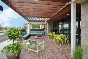 un patio avec des tables et des chaises dans un bâtiment dans l'établissement Home2 Suites By Hilton Frankfort, à Frankfort