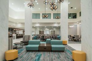 een lobby van een hotel met stoelen en tafels bij Hilton Garden Inn Jackson/Clinton in Clinton
