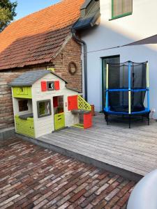 ein Spielzeughundehaus auf einem Deck neben einem Haus in der Unterkunft Ubytování U Starých in Zaječí