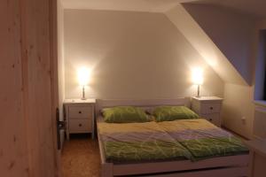 a bedroom with a bed with two lights on the sides at Ubytování U Starých in Zaječí