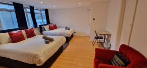 ein Wohnzimmer mit 2 Betten und einem roten Sofa in der Unterkunft The Copper fields in London
