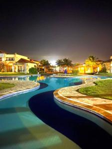 a large swimming pool with blue water at night at Búzios beach resort in Búzios