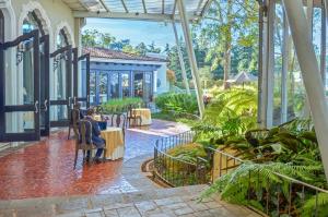 a courtyard with people sitting at tables in a garden at Hilton Guatemala City, Guatemala in Guatemala