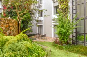 a garden in front of a building with plants at Hilton Guatemala City, Guatemala in Guatemala +57 photos