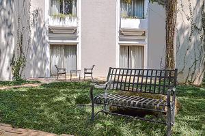 two benches sitting in the grass in front of a building at Hilton Guatemala City, Guatemala in Guatemala
