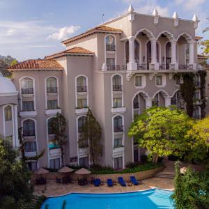 een groot gebouw met een zwembad ervoor bij Hilton Guatemala City, Guatemala in Guatemala