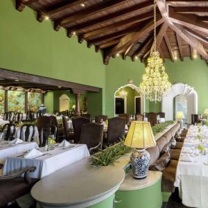 een restaurant met tafels en stoelen en een kroonluchter bij Hilton Guatemala City, Guatemala in Guatemala