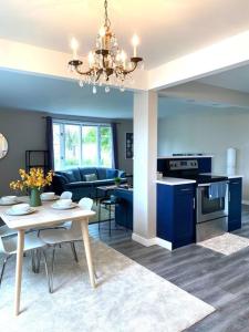 a kitchen and living room with a table and blue cabinets at Modern and Spacious Home in St. Vital in Winnipeg