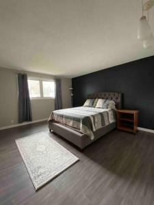 a bedroom with a bed and a black wall at Modern and Spacious Home in St. Vital in Winnipeg