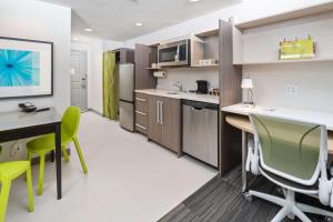 Home2 Suites By Hilton Newark Airport في نيوآرك: مطبخ مع طاولة وكراسي في غرفة