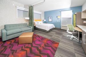 a hotel room with a bed and a couch at Home2 Suites By Hilton Newark Airport in Newark