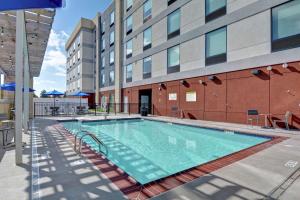 a swimming pool in front of a building at Home2 Suites By Hilton Springdale in Springdale