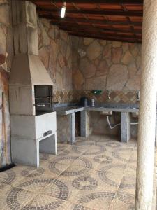 a kitchen with a stove and a stone wall at Casa De Benedictis Rio de Contas in Rio de Contas