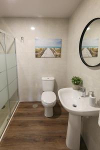 a bathroom with a toilet and a sink and a mirror at Modern Apartment With Garden in Fátima
