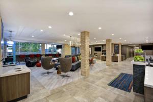 休斯顿Home2 Suites Houston Westchase的一个带前台和椅子的办公大厅