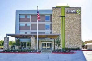 a front view of a hotel with an american flag at Home2 Suites Houston Westchase in Houston