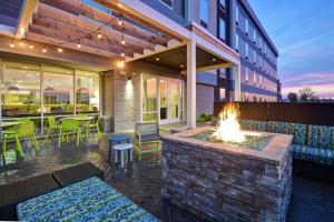 a patio with a fire pit and a building at Home2 Suites By Hilton Terre Haute in Terre Haute