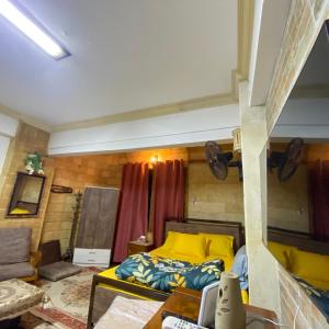 1 dormitorio con cama amarilla y sofá en Sunny-suite in new Cairo en El Cairo