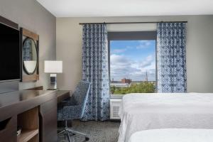 フォートウェインにあるHampton Inn & Suites Fort Wayne Downtownのベッドと窓が備わるホテルルーム