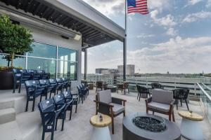 un patio con sedie, tavoli e bandiera americana di Hampton Inn & Suites Fort Wayne Downtown a Fort Wayne