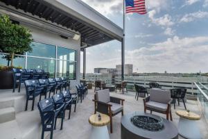 d'une terrasse avec des chaises, des tables et un drapeau américain. dans l'établissement Hampton Inn & Suites Fort Wayne Downtown, à Fort Wayne