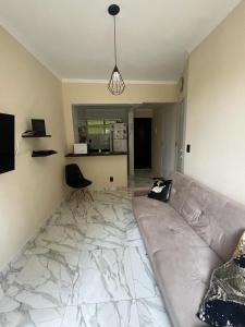 ein Wohnzimmer mit einem Sofa und einer Küche in der Unterkunft Apartamento em Ilha Porchat in São Vicente