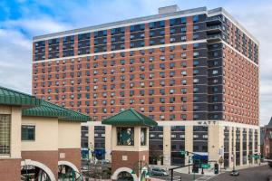 ein hohes rotes Backsteingebäude in einer Stadt in der Unterkunft Watt Hotel Tapestry Collection by Hilton in Rahway