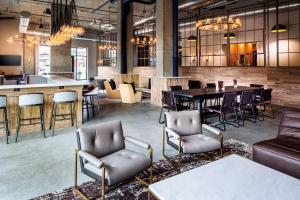 eine Lobby mit einem Tisch und Stühlen sowie einer Bar in der Unterkunft Watt Hotel Tapestry Collection by Hilton in Rahway