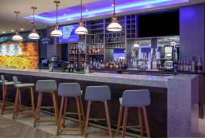 um bar com bancos brancos num restaurante em DoubleTree by Hilton Hot Springs em Hot Springs