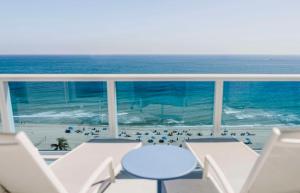 a view of the ocean from a balcony with chairs and a beach at Hotel Maren Fort Lauderdale Beach, Curio Collection By Hilton in Fort Lauderdale