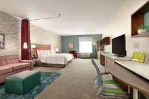 um grande quarto de hotel com uma cama e uma secretária em Home2 Suites By Hilton Easton em Easton