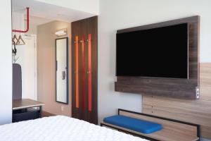 a bedroom with a flat screen tv on a wall at Tru By Hilton Fort Lauderdale Downtown-Flagler Village in Fort Lauderdale