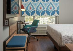 a hospital room with a bed and a chair and a window at Tru By Hilton Fort Lauderdale Downtown-Flagler Village in Fort Lauderdale
