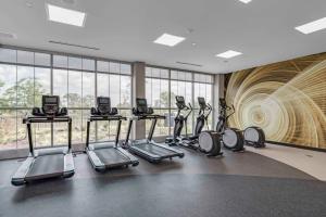 un gimnasio con varias máquinas de correr en una habitación con ventanas en Home2 Suites By Hilton Fort Wayne North, en Sunnybrook Acres