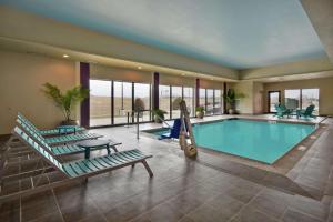 une grande piscine avec 2 chaises longues et une balançoire dans l'établissement Home2 Suites by Hilton Wichita Northeast, à Wichita