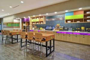 a restaurant with a bar with chairs and a counter at Home2 Suites by Hilton Wichita Northeast in Wichita