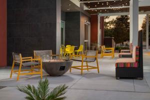 un grupo de sillas, mesas y sillas en un patio en Home2 Suites By Hilton Clovis Fresno Airport, en Clovis