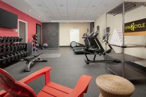 a gym with cardio equipment and a red wall at Home2 Suites By Hilton Clovis Fresno Airport in Clovis