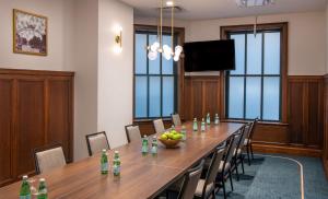 uma sala de conferências com uma longa mesa e cadeiras de madeira em Hilton Garden Inn Flint Downtown em Flint