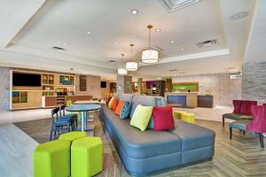 傑克孫維的住宿－Home2 Suites By Hilton Jacksonville South St Johns Town Ctr，客厅配有蓝色沙发及色彩缤纷的枕头