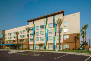 ein Apartmenthaus mit blauen und gelben Streifen in der Unterkunft Tru By Hilton Goodyear Phoenix West, Az in Goodyear