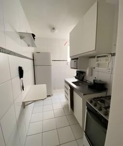 a white kitchen with a stove and white cabinets at Ap 2/4 Prox ao shopping in Feira de Santana